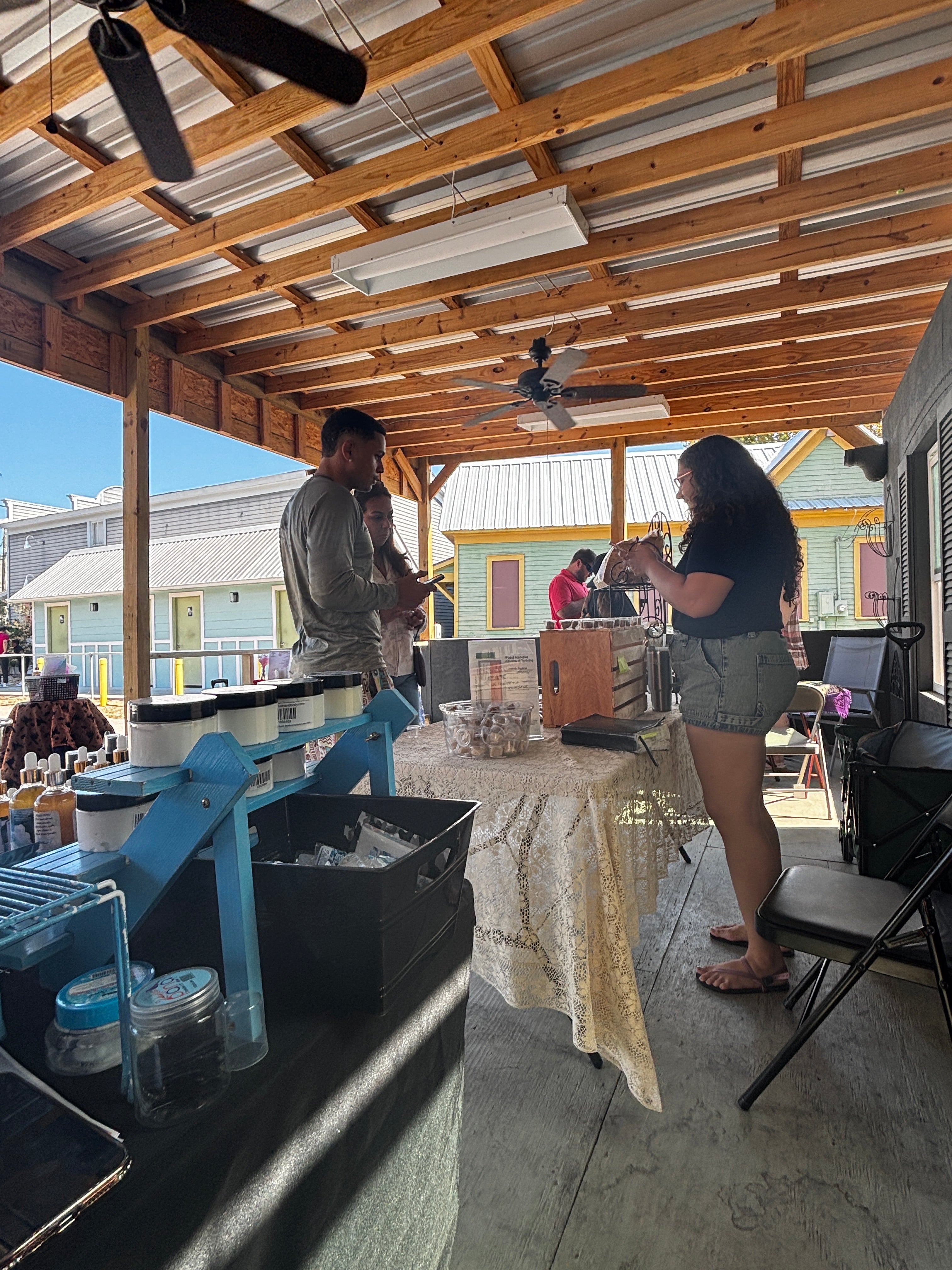 People standing on a patio with wooden beams and a clear sky.